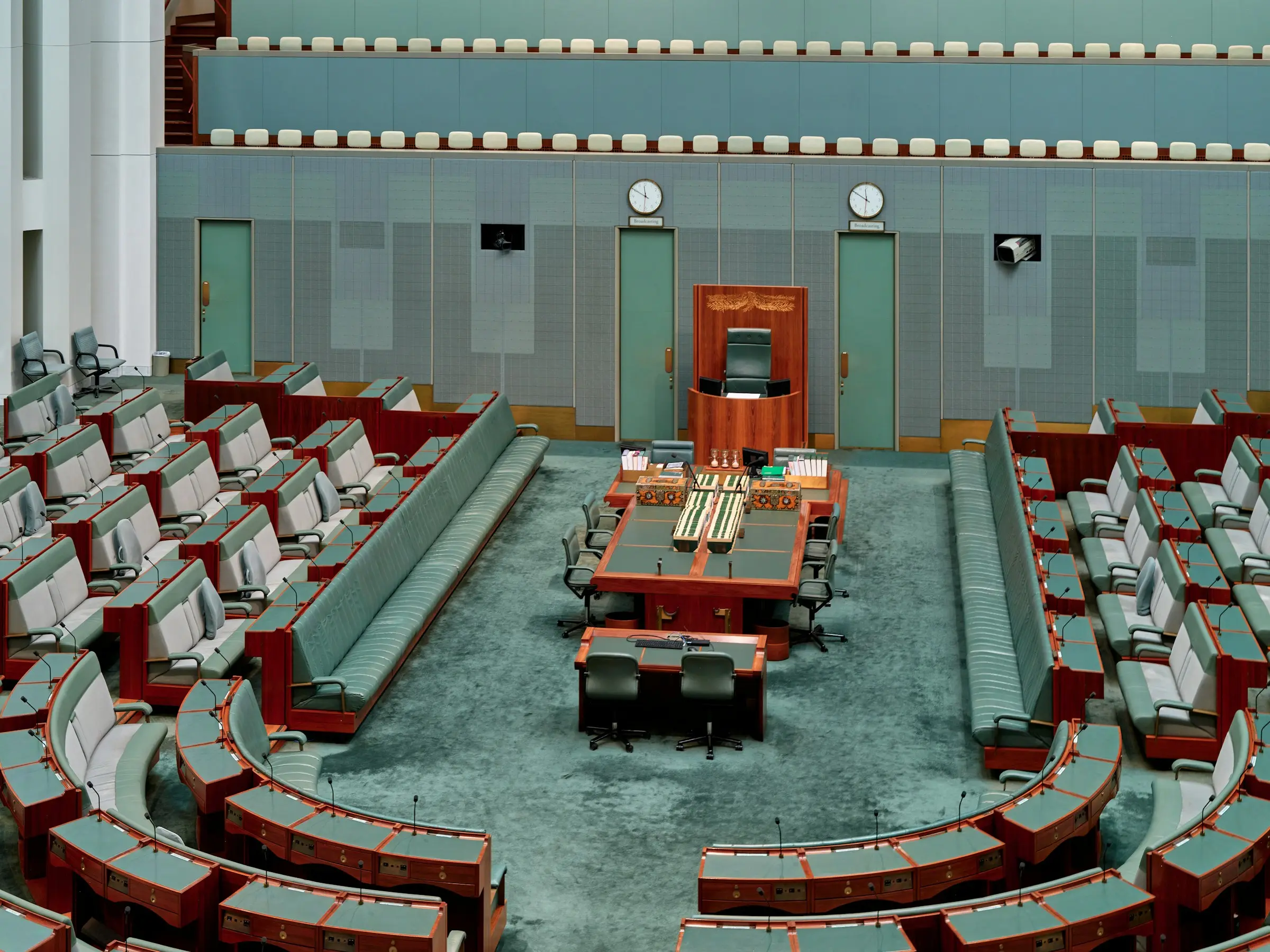 An empty horseshoe-shaped debating chamber, rows of seats facing the centre