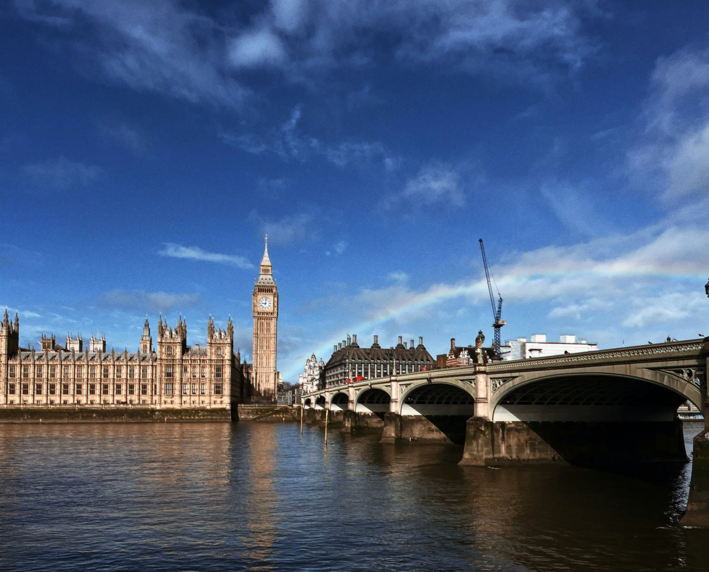 The Houses of Parliament and Westminster Bridge across the Thames under a bright sky
